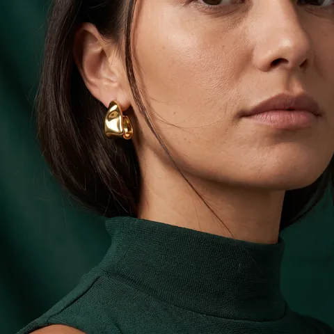 Gouden oorbel van Zela Atelier, gedragen